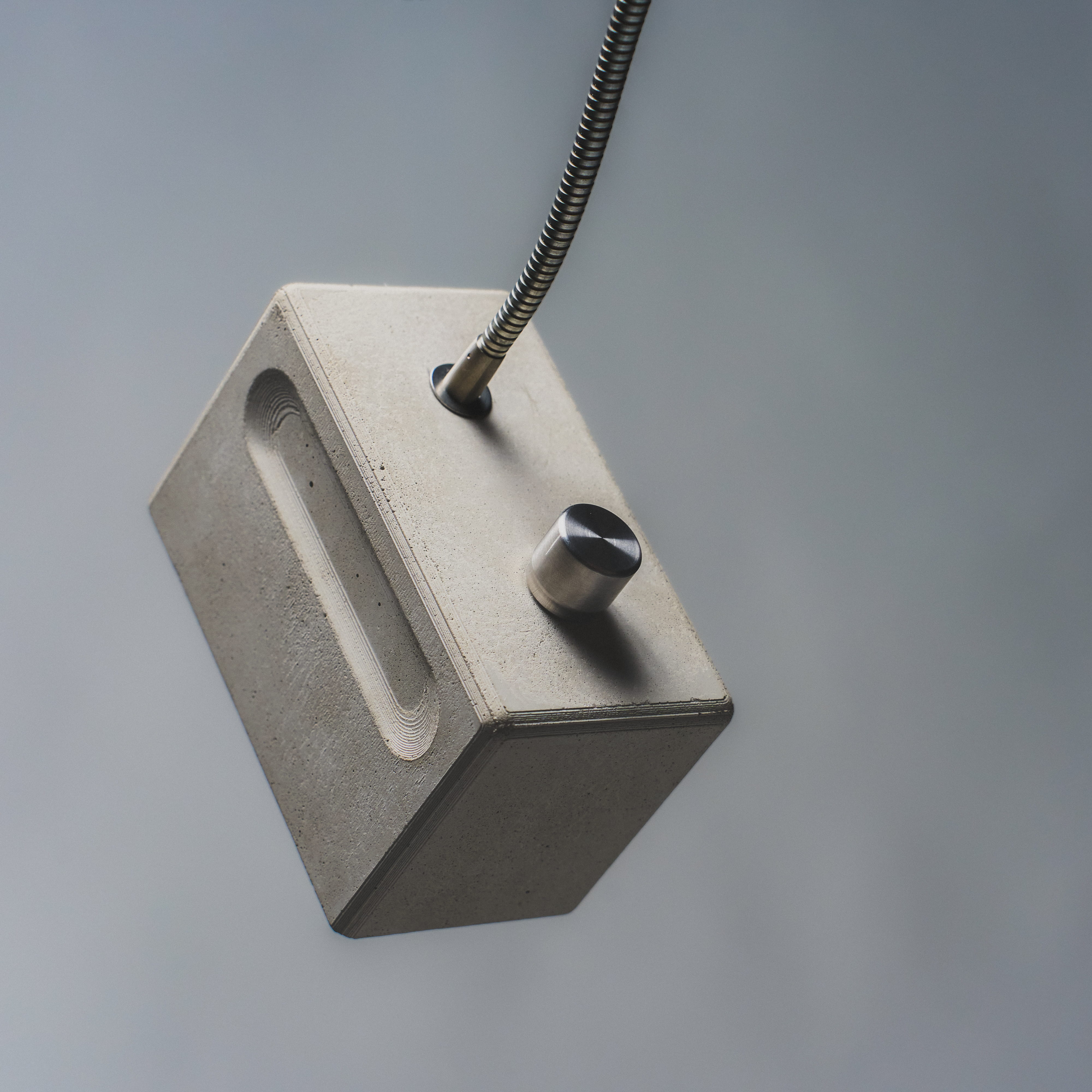 Détail du bloc en béton — texture et bouton en acier inoxydable